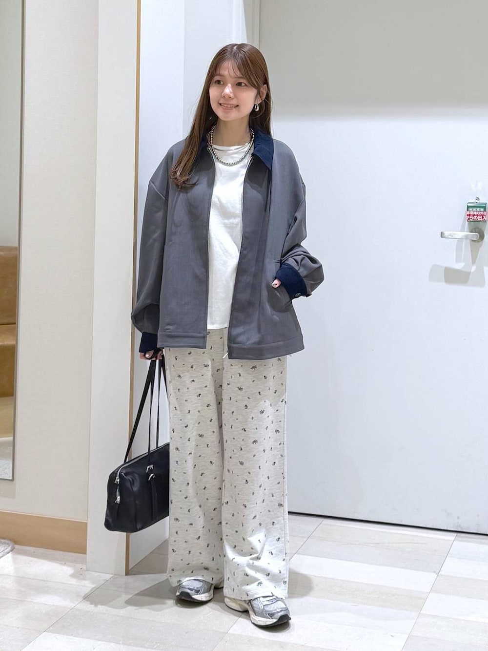 ホワイト系のTシャツ/カットソー、ブラック系のショルダーバッグ、グレー系のブルゾンを着用したレディースの春コーディネートの4枚目の写真