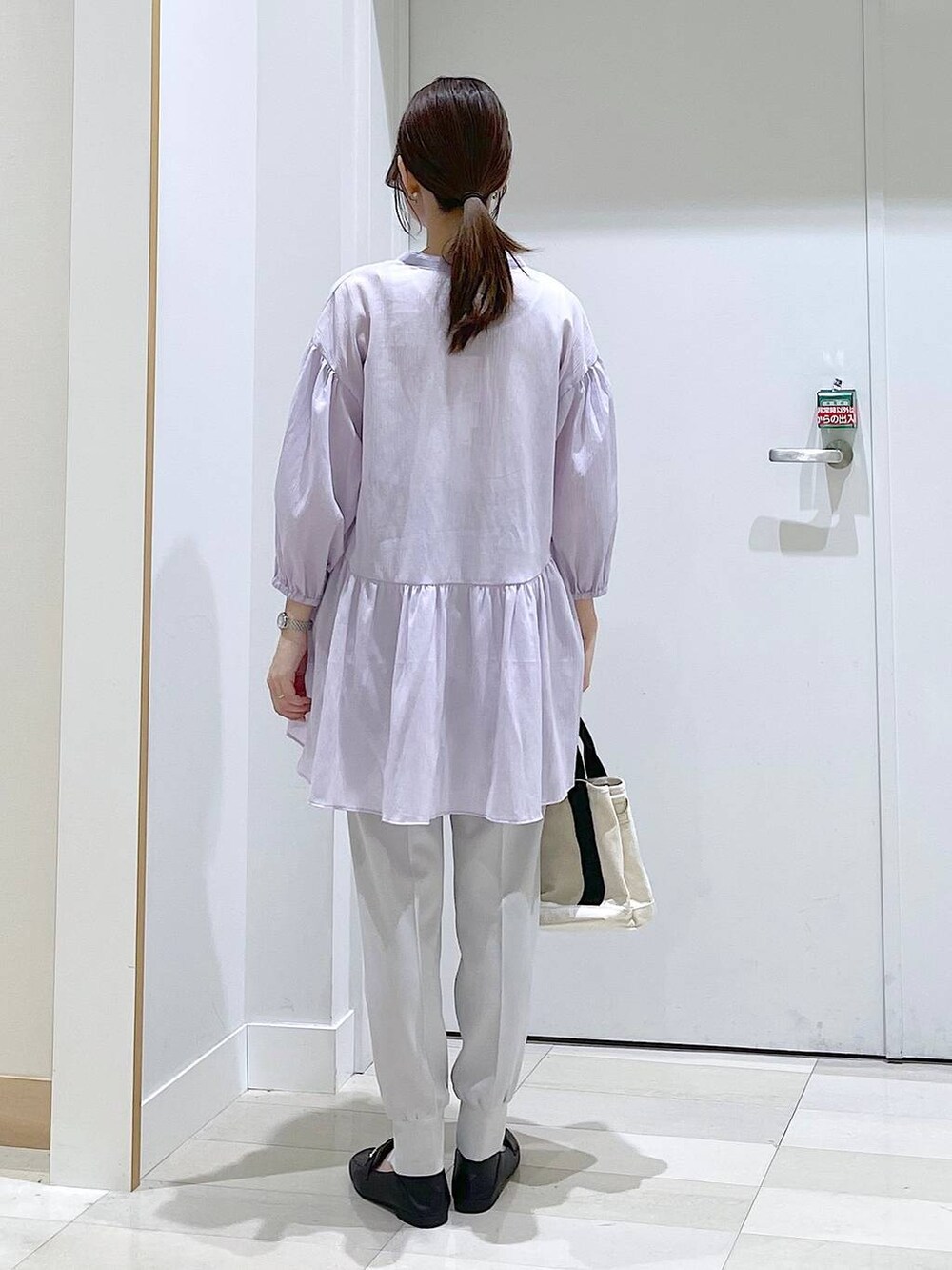 ブラック系のローファー、グレー系のその他パンツ、ホワイト系のトートバッグを着用したレディースの春コーディネートの3枚目の写真