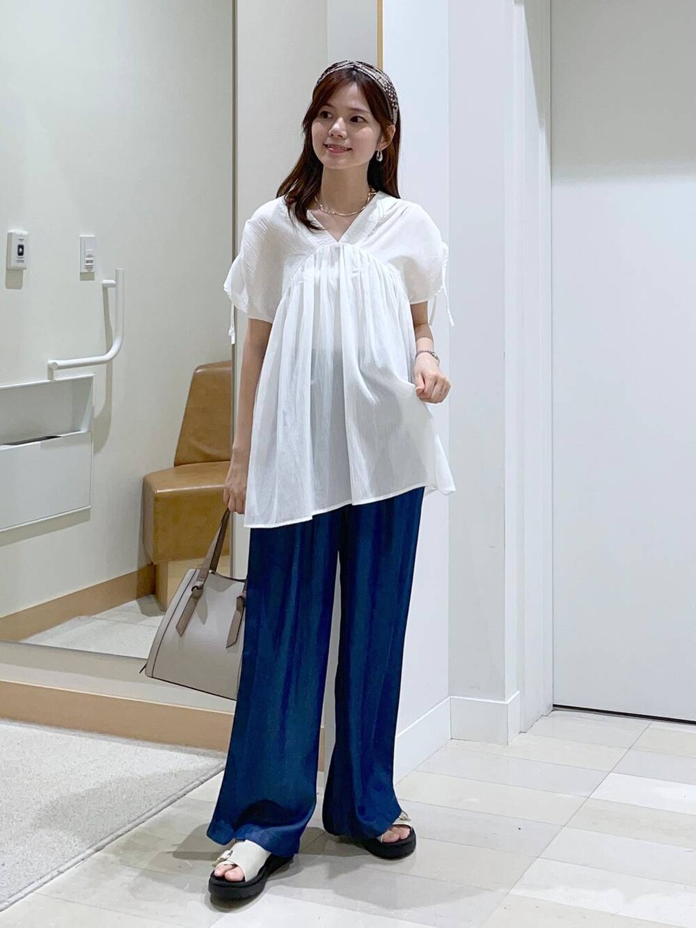 ホワイト系のショルダーバッグ、ホワイト系のサンダル、ホワイト系のシャツ/ブラウスを着用したレディースの春コーディネートの4枚目の写真