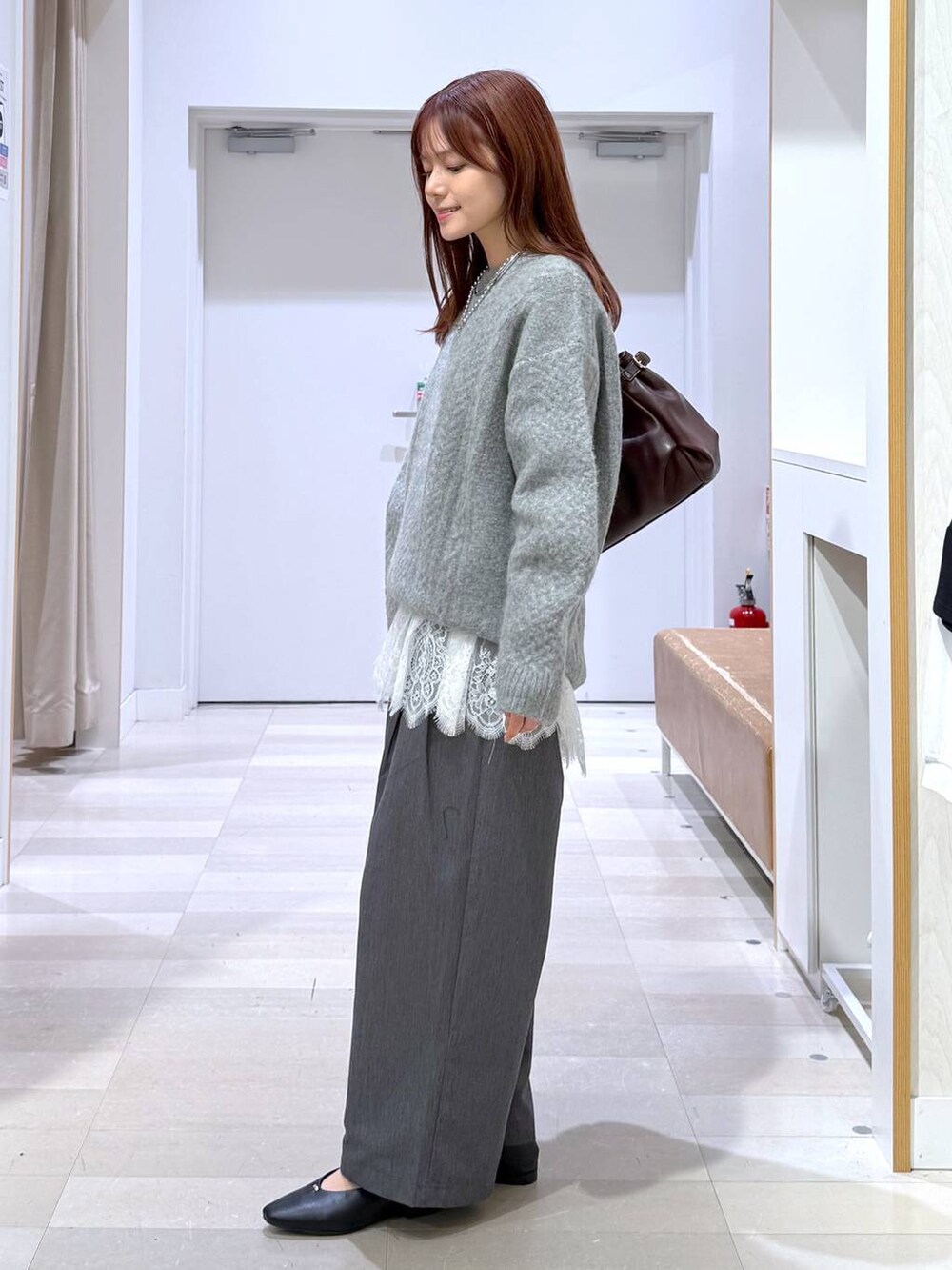ブラック系のパンプス、レッド系のボストンバッグ、グレー系のその他パンツを着用したレディースの秋コーディネートの2枚目の写真