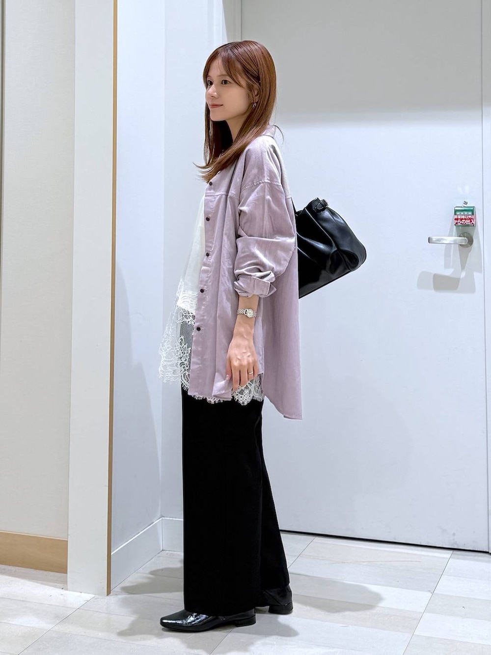 ブラック系のボストンバッグ、ブラック系のパンプス、ホワイト系のキャミソールを着用したレディースの秋コーディネートの2枚目の写真