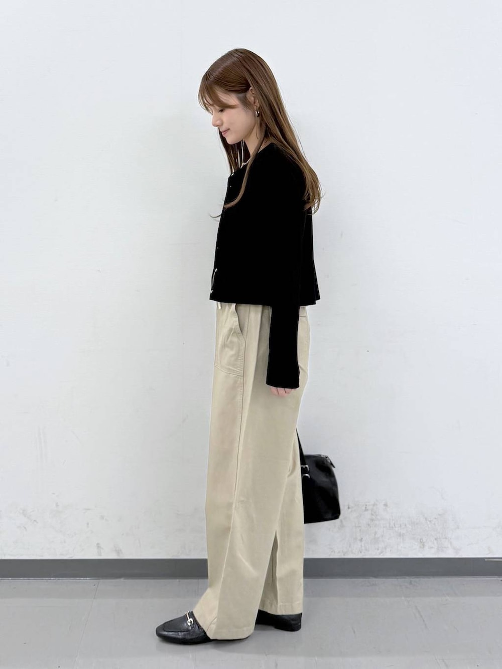 ブラック系のローファー、ベージュ系のその他パンツ、ブラック系のショルダーバッグを着用したレディースの春コーディネートの2枚目の写真