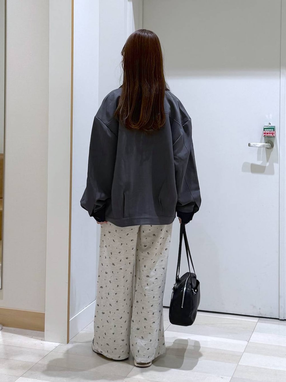 ホワイト系のTシャツ/カットソー、ブラック系のショルダーバッグ、グレー系のブルゾンを着用したレディースの春コーディネートの3枚目の写真