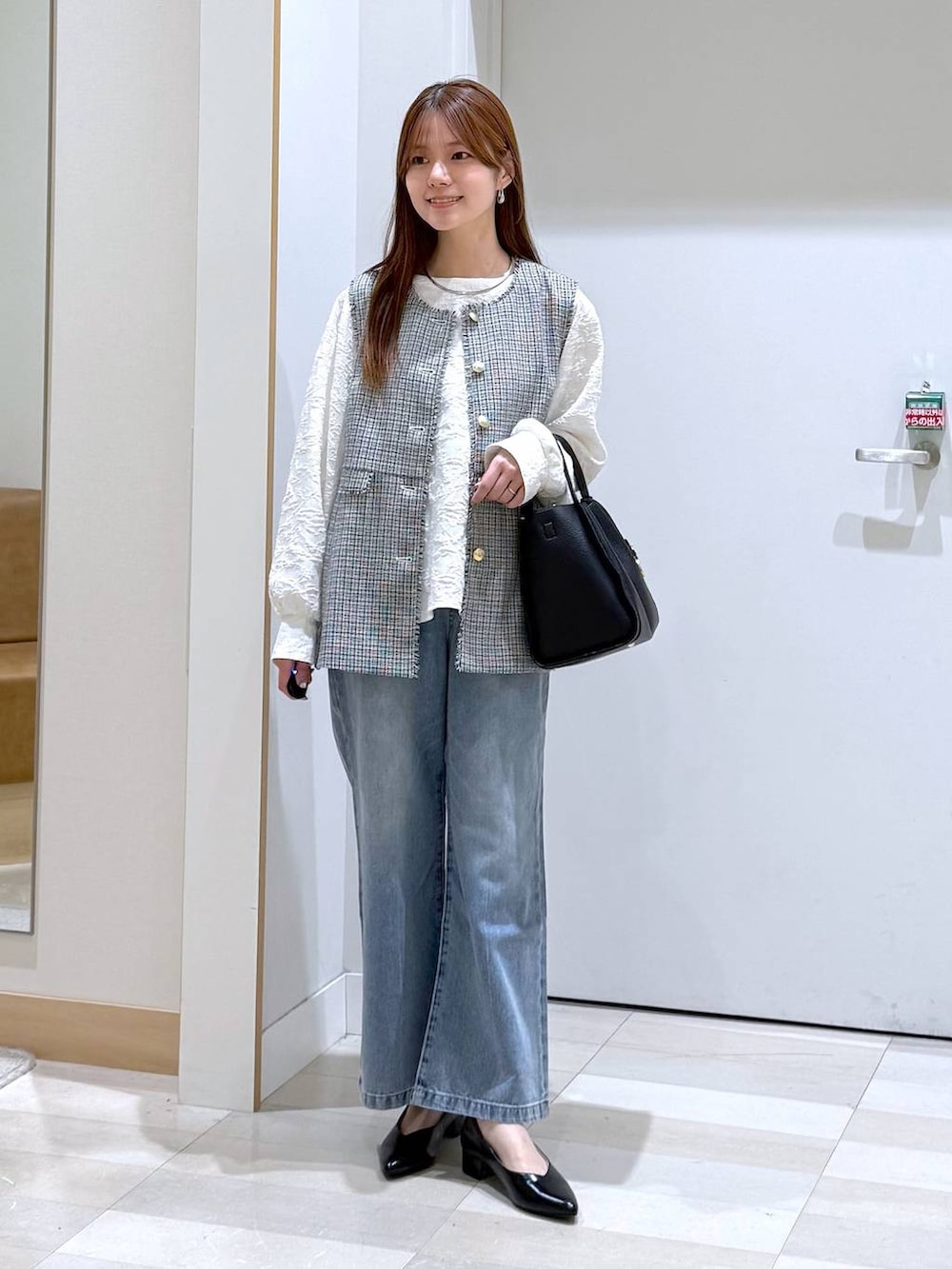 ブルー系のデニムパンツ、ブラック系のパンプス、ブラック系のトートバッグを着用したレディースの春コーディネートの5枚目の写真