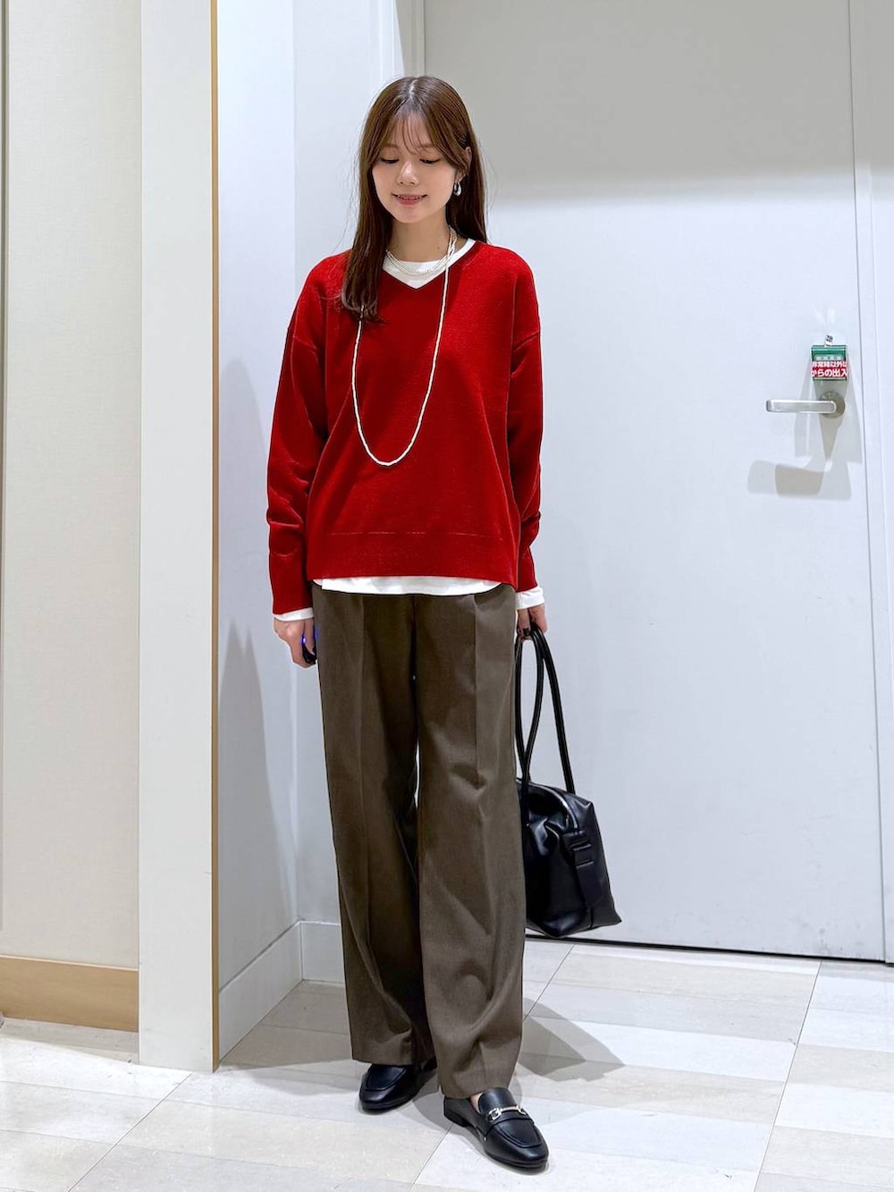 ブラック系のローファー、ブラック系のボストンバッグ、ホワイト系のTシャツ/カットソーを着用したレディースの秋コーディネートの4枚目の写真