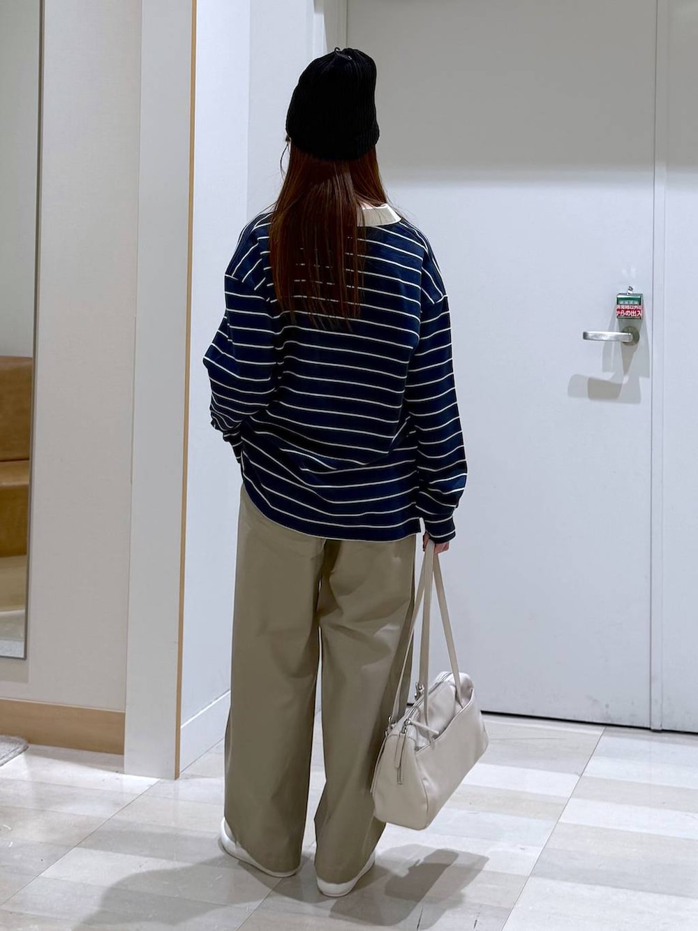 ホワイト系のスニーカー、ブルー系のスウェット、ベージュ系のショルダーバッグを着用したレディースの春コーディネートの3枚目の写真