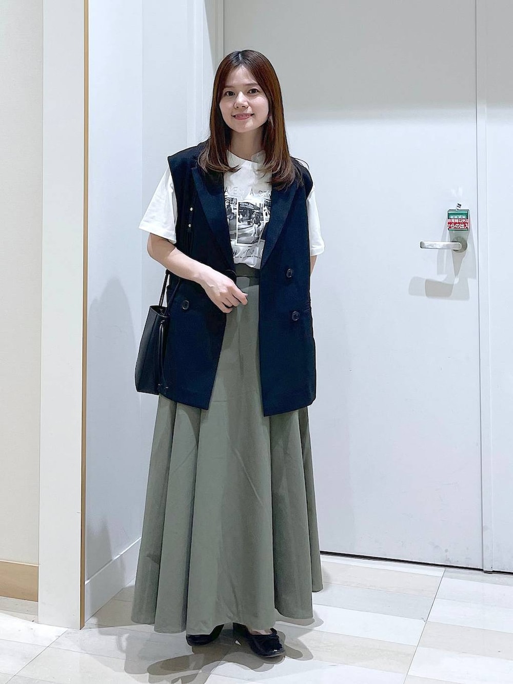 ブラック系のバレエシューズ、ブラック系のベスト、ホワイト系のTシャツ/カットソーを着用したレディースの春コーディネートの4枚目の写真