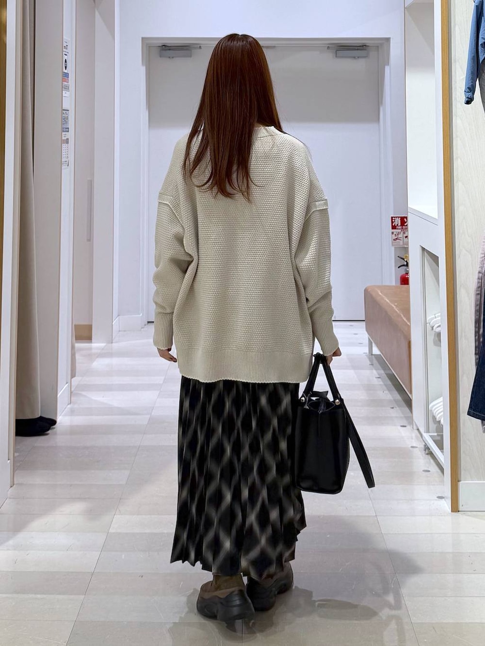 ベージュ系のカーディガン/ボレロ、ブラウン系のブーツ、ピンク系のニット/セーターを着用したレディースの冬コーディネートの3枚目の写真