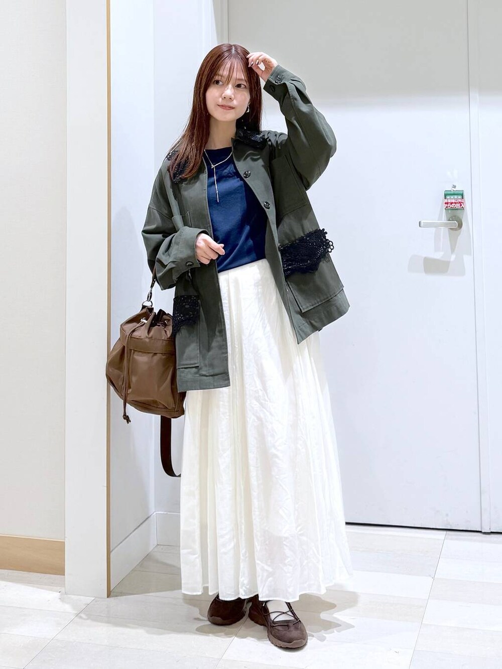 ブラウン系のショルダーバッグ、ベージュ系のスカート、ブルー系のTシャツ/カットソーを着用したレディースの秋コーディネートの4枚目の写真