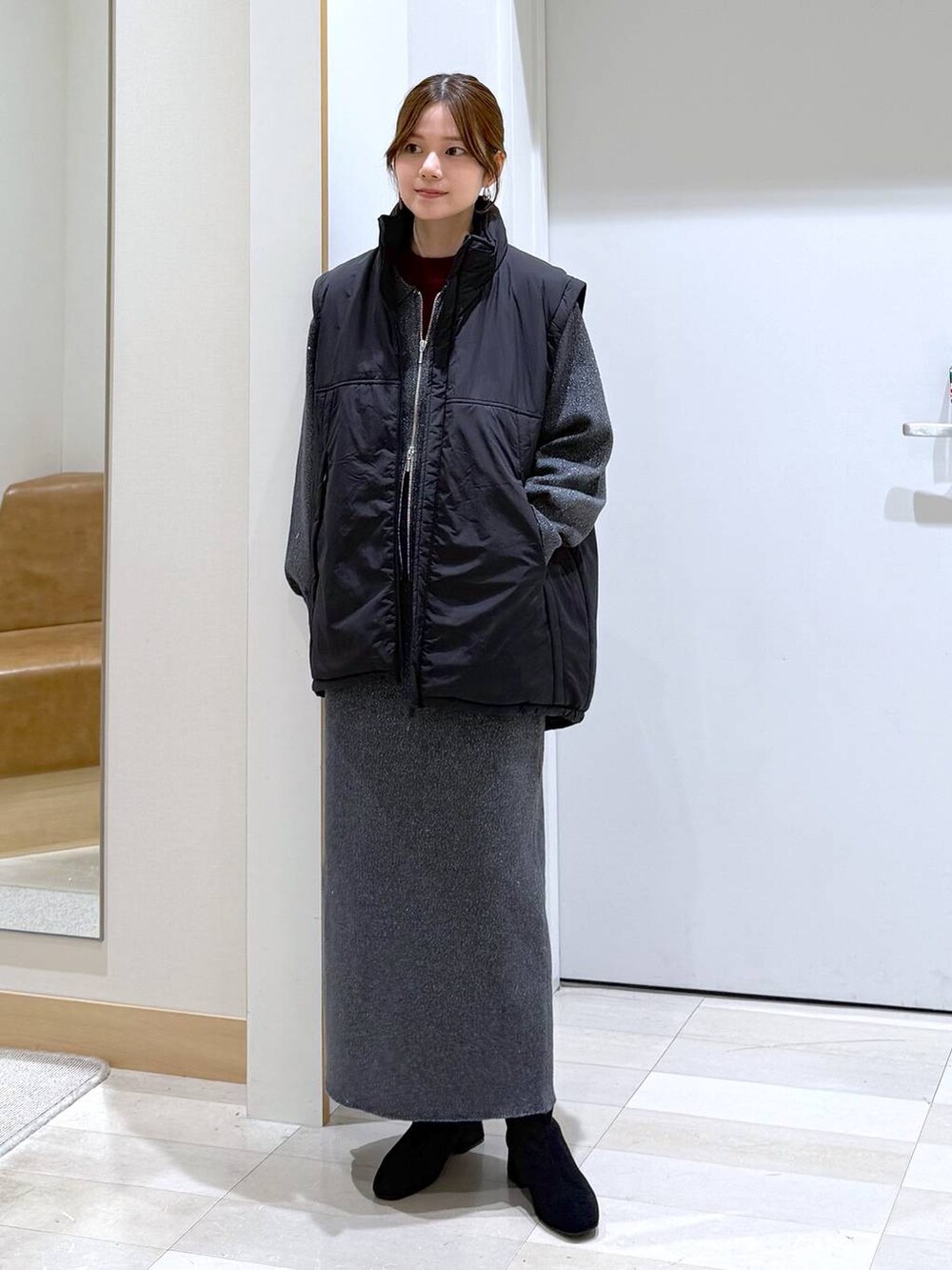 ブラック系のブルゾン、レッド系のニット/セーター、グレー系のワンピースを着用したレディースの秋コーディネートの4枚目の写真