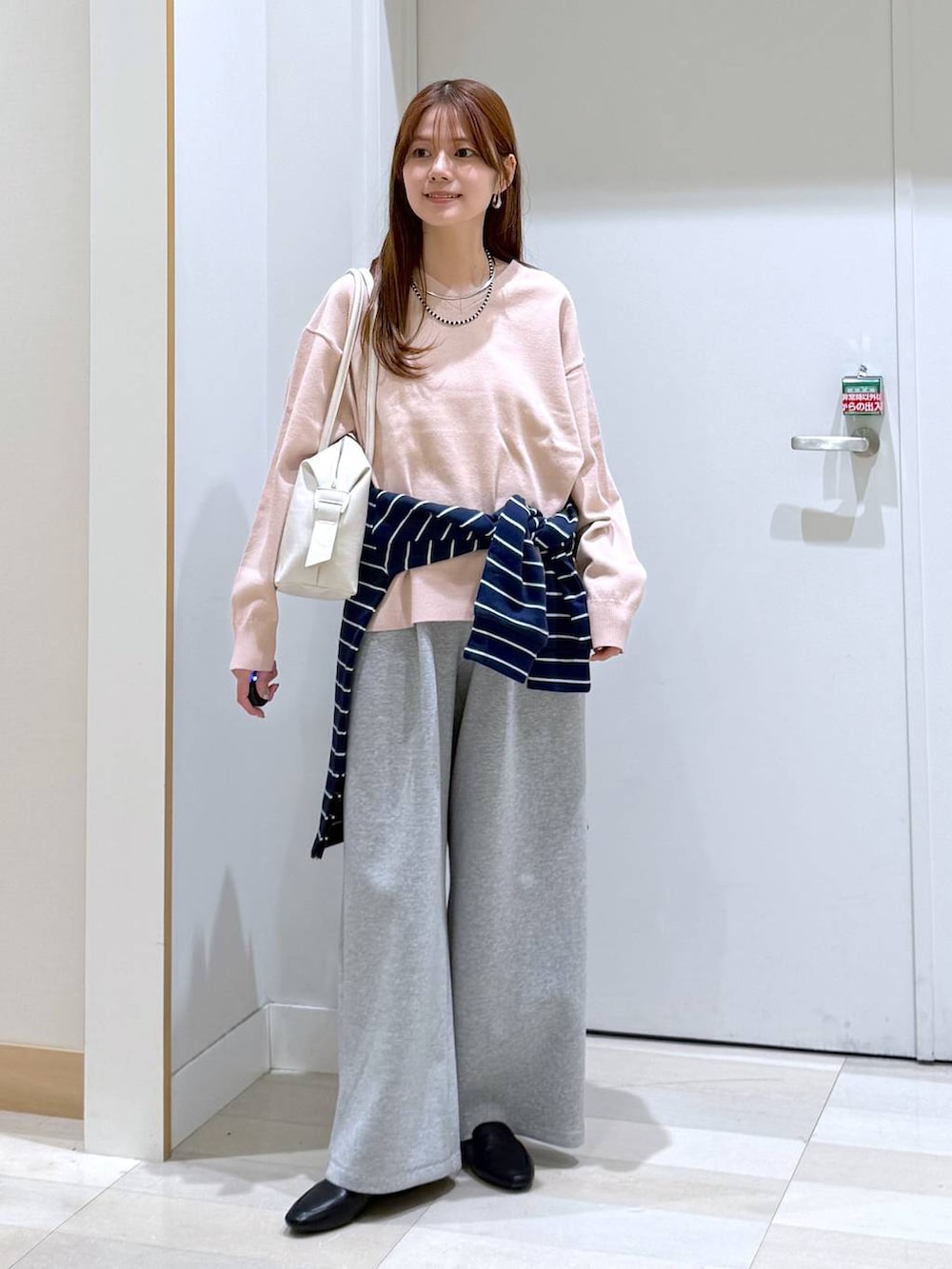 ブラック系のその他シューズ、ホワイト系のボストンバッグ、グレー系のスウェットパンツを着用したレディースの春コーディネートの4枚目の写真