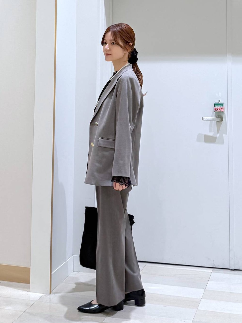 ブラック系のパンプス、ブラック系のシャツ/ブラウス、ブラウン系のスラックスを着用したレディースの冬コーディネートの2枚目の写真