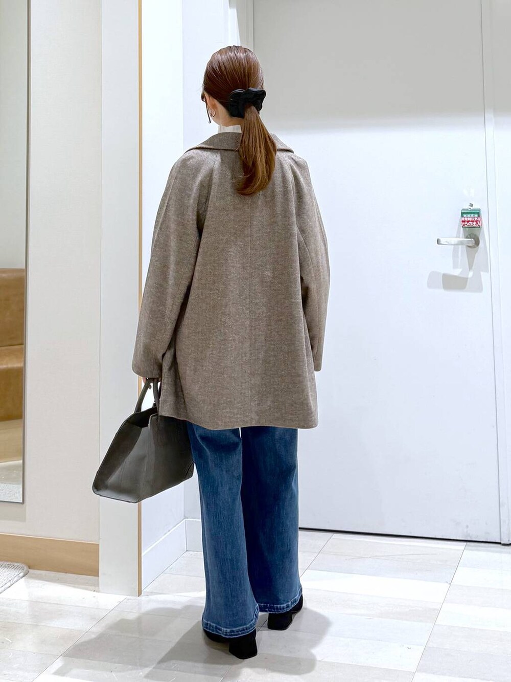 ブラウン系のチェスターコート、グリーン系のショルダーバッグ、ホワイト系のニット/セーターを着用したレディースの秋コーディネートの3枚目の写真