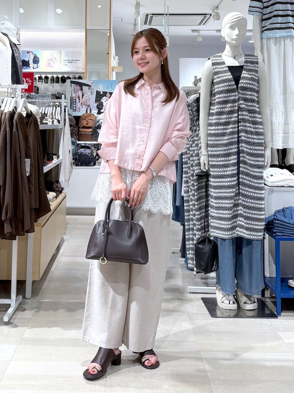 ブラウン系のショルダーバッグ、ベージュ系のその他パンツ、ピンク系のシャツ/ブラウスを着用したレディースの夏コーディネートの4枚目の写真