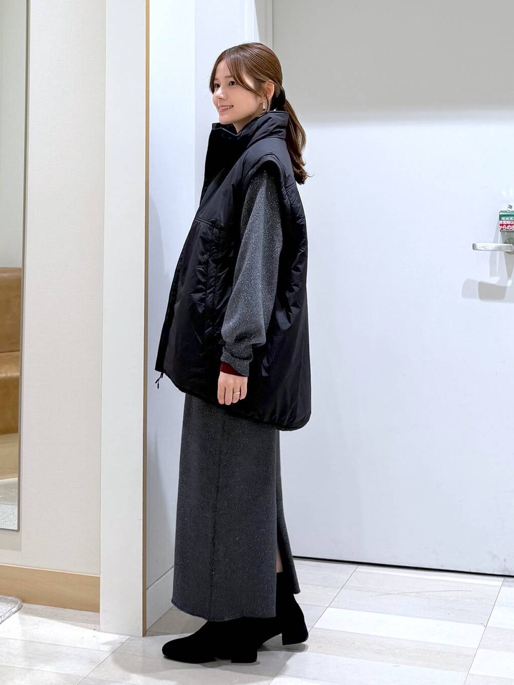 ブラック系のブルゾン、レッド系のニット/セーター、グレー系のワンピースを着用したレディースの秋コーディネートの2枚目の写真