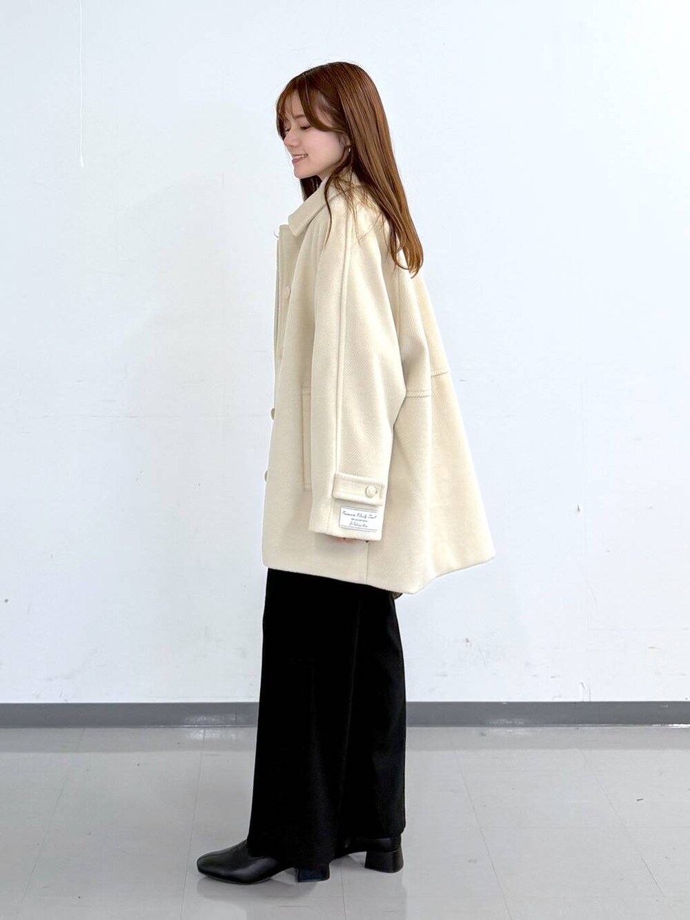 ホワイト系のニット/セーター、ブラック系のその他パンツ、ホワイト系のTシャツ/カットソーを着用したレディースの冬コーディネートの2枚目の写真