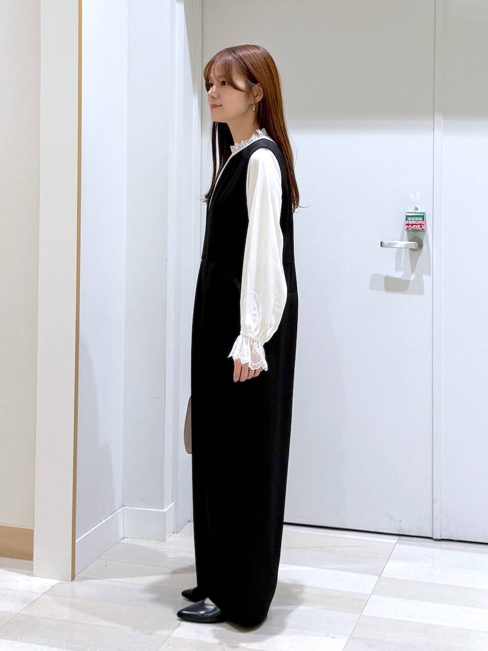 ベージュ系のショルダーバッグ、ブラック系のパンプス、ホワイト系のシャツ/ブラウスを着用したレディースの冬コーディネートの2枚目の写真