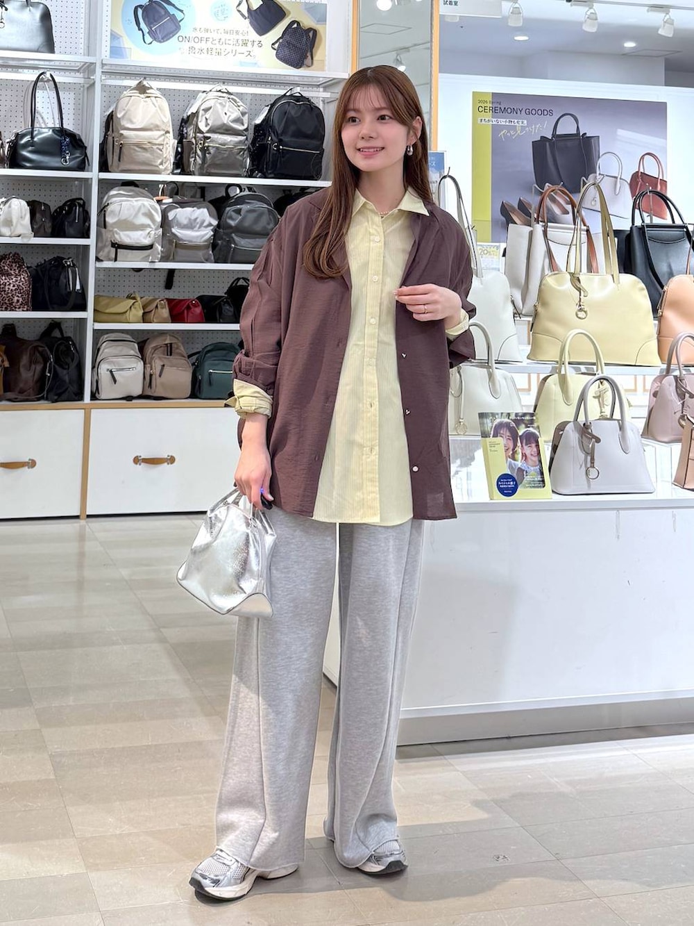 シルバー系のショルダーバッグ、イエロー系のシャツ/ブラウス、グレー系のスウェットパンツを着用したレディースの春コーディネートの5枚目の写真