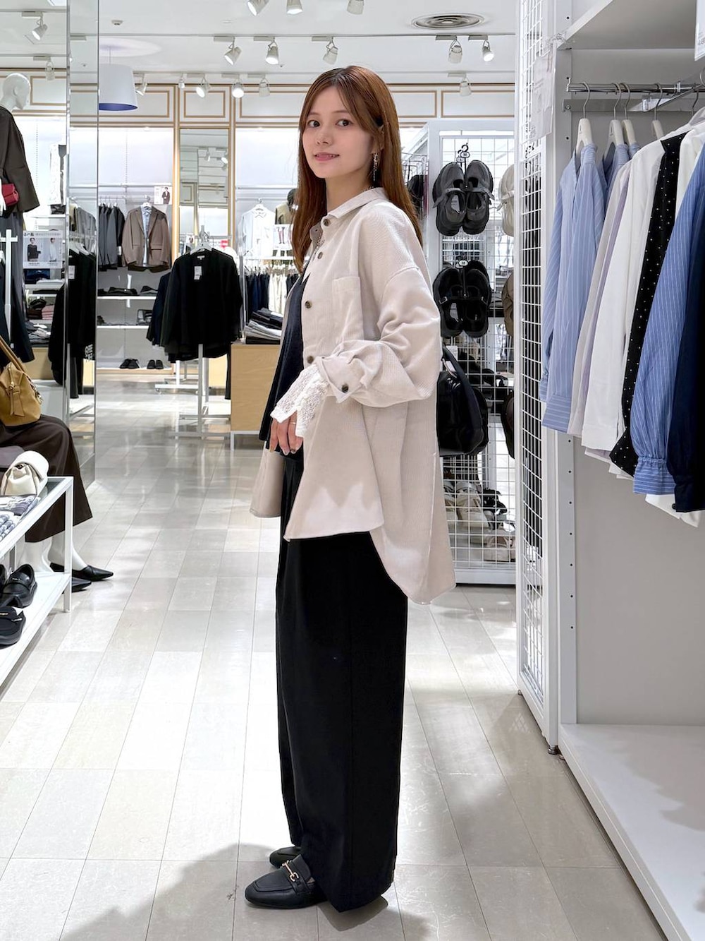 ブルー系のベスト、ホワイト系のTシャツ/カットソー、ブラック系のローファーを着用したレディースの秋コーディネートの2枚目の写真