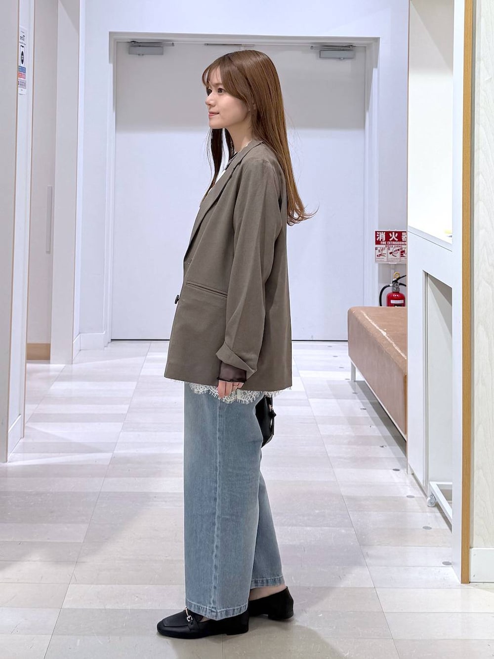 ブラック系のローファー、ブラック系のショルダーバッグ、ブルー系のデニムパンツを着用したレディースの春コーディネートの2枚目の写真