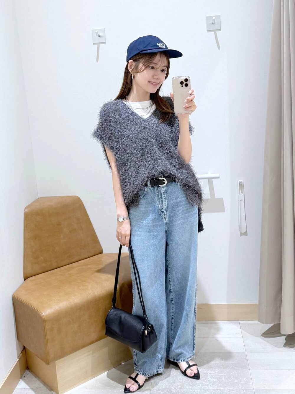 ブルー系のデニムパンツ、ホワイト系のTシャツ/カットソー、ブラック系のショルダーバッグを着用したレディースの秋コーディネートの2枚目の写真