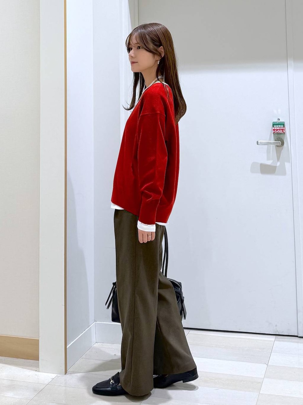 ブラック系のローファー、ブラック系のボストンバッグ、ホワイト系のTシャツ/カットソーを着用したレディースの秋コーディネートの2枚目の写真