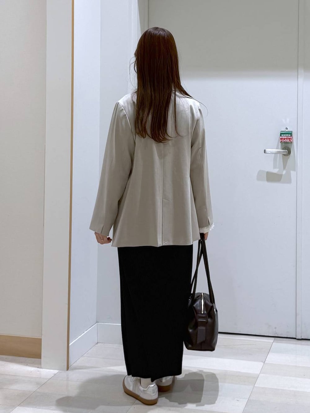 ホワイト系のスニーカー、ブラウン系のボストンバッグ、ホワイト系のTシャツ/カットソーを着用したレディースの春コーディネートの3枚目の写真