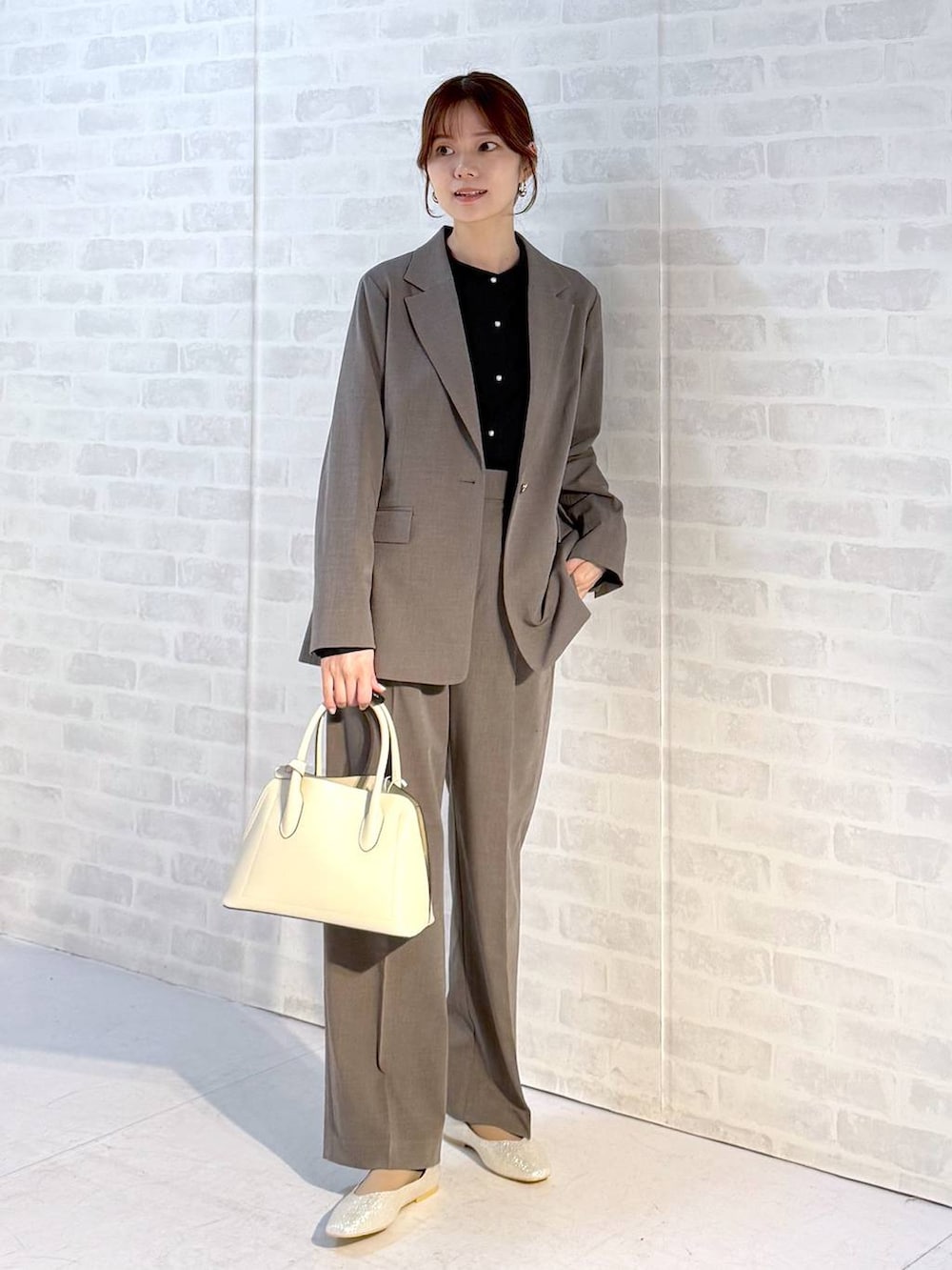 ベージュ系のパンプス、ホワイト系のショルダーバッグ、ブラウン系のスラックスを着用したレディースの冬コーディネートの4枚目の写真