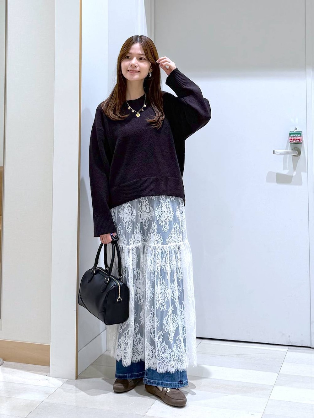 ブラウン系のワンピース、ブラウン系のローファー、ブラック系のボストンバッグを着用したレディースの秋コーディネートの4枚目の写真