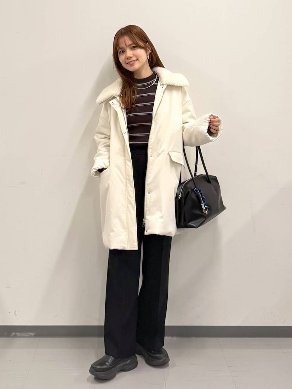 ブラック系のボストンバッグ、ブラック系のその他パンツ、ブラック系のブーツを着用したレディースの冬コーディネートの5枚目の写真