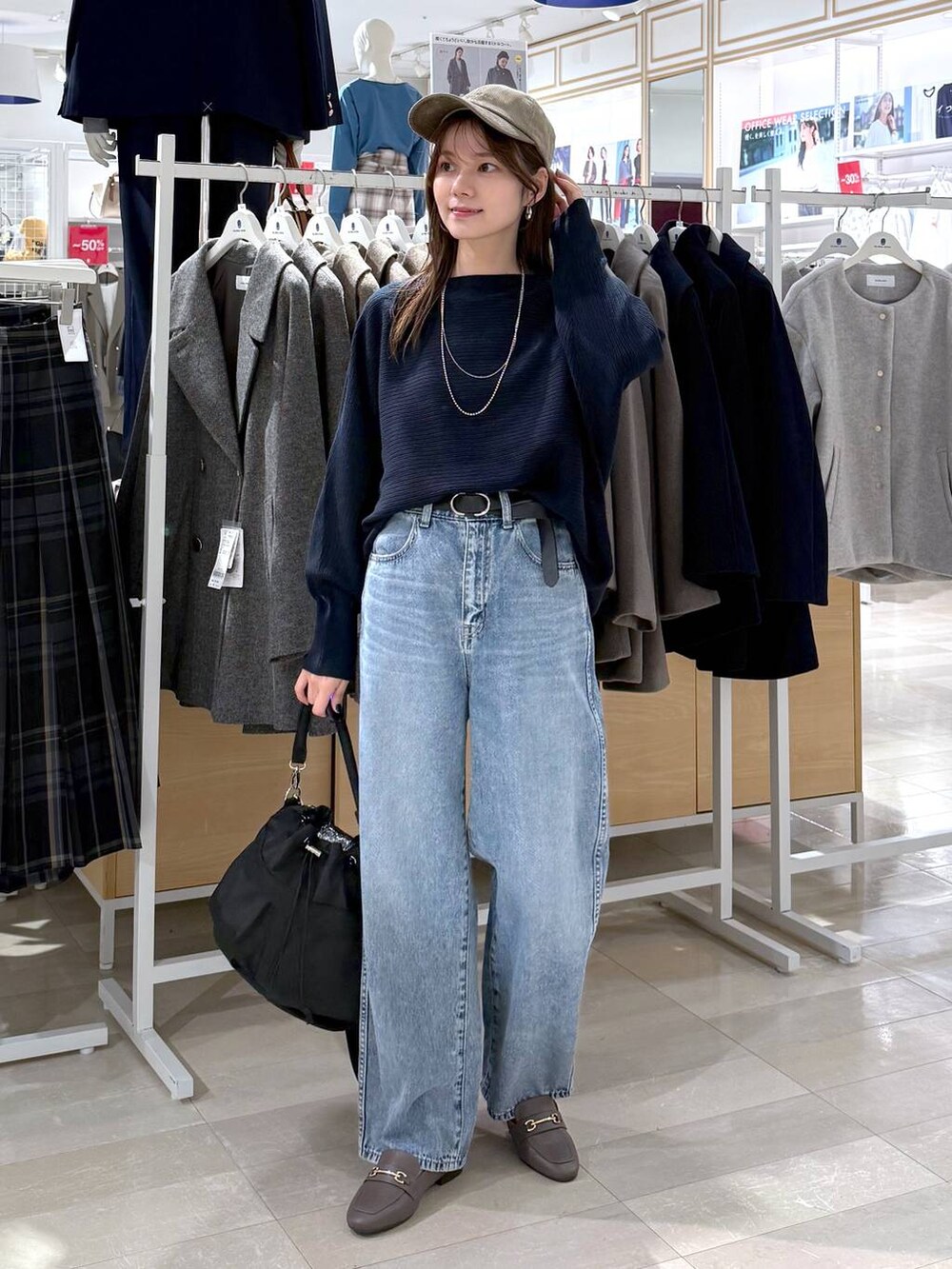 ベージュ系のローファー、ブラック系のショルダーバッグ、ブルー系のデニムパンツを着用したレディースの秋コーディネートの5枚目の写真