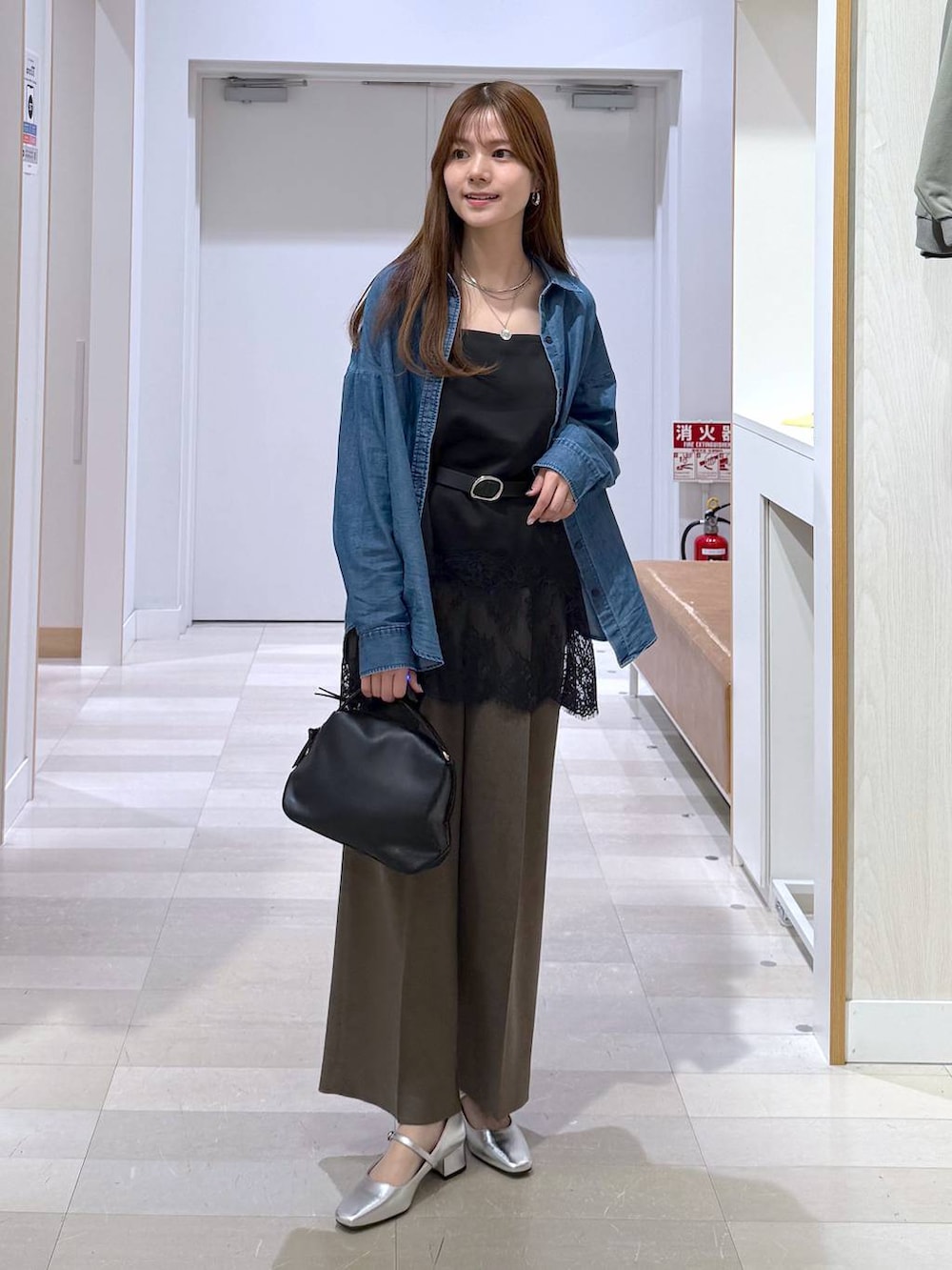 ブラック系のショルダーバッグ、ブルー系のシャツ/ブラウス、ブラック系のキャミソールを着用したレディースの春コーディネートの4枚目の写真