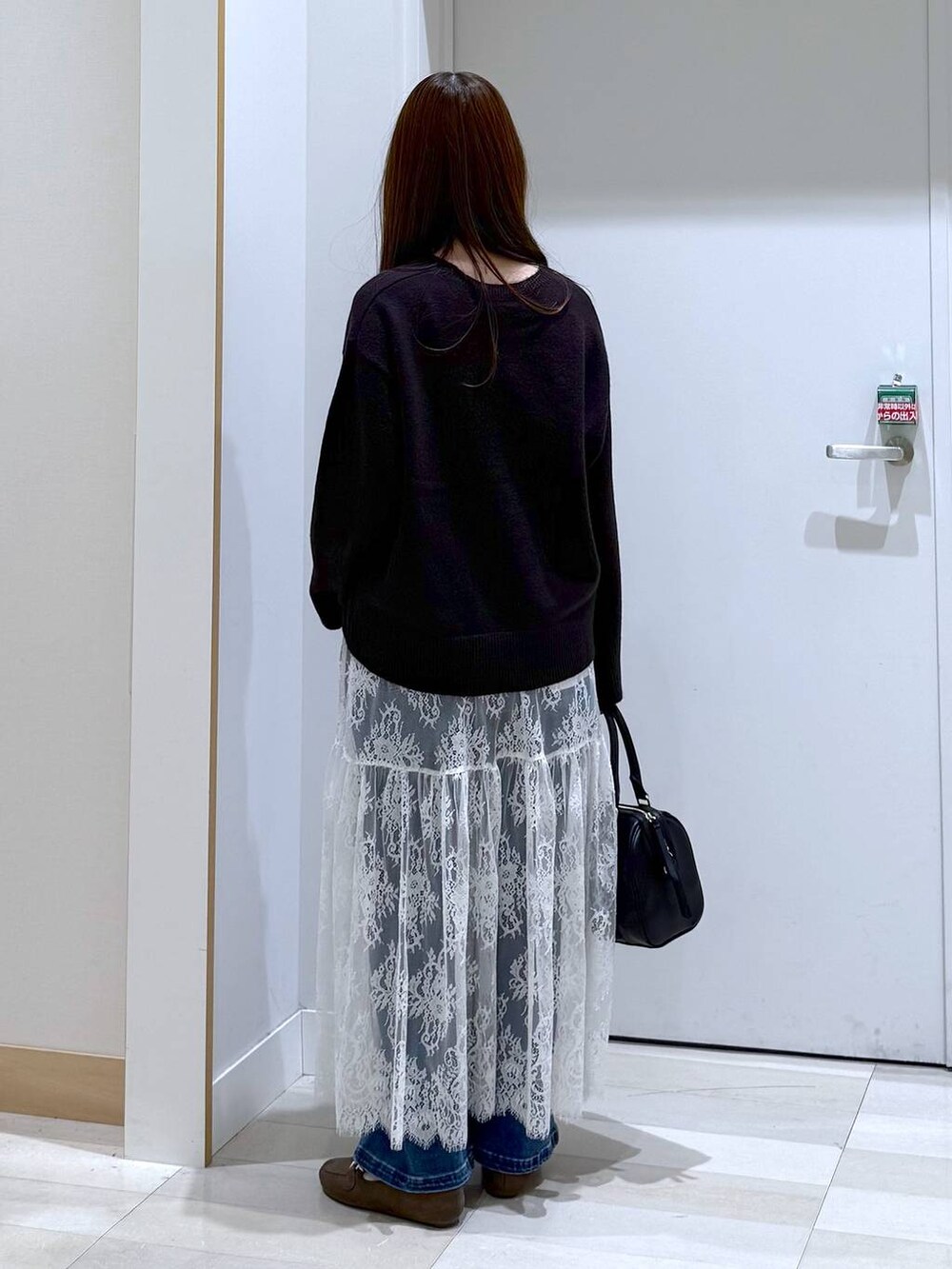 ブラウン系のワンピース、ブラウン系のローファー、ブラック系のボストンバッグを着用したレディースの秋コーディネートの3枚目の写真