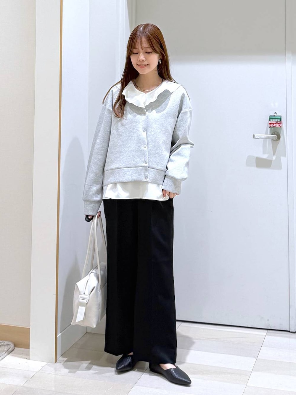 ブラック系のパンプス、ホワイト系のボストンバッグ、ブラック系のその他パンツを着用したレディースの冬コーディネートの4枚目の写真