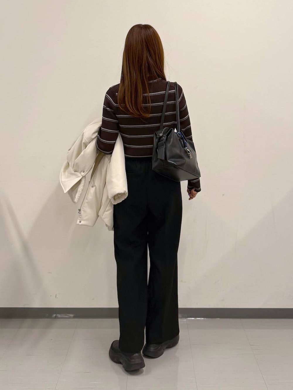 ブラック系のボストンバッグ、ブラック系のその他パンツ、ブラック系のブーツを着用したレディースの冬コーディネートの3枚目の写真