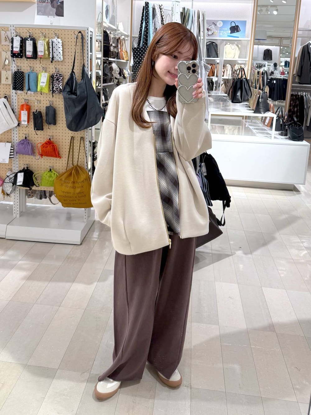 ホワイト系のスニーカー、ホワイト系のブルゾン、ブラウン系のその他トップスを着用したレディースの冬コーディネートの6枚目の写真