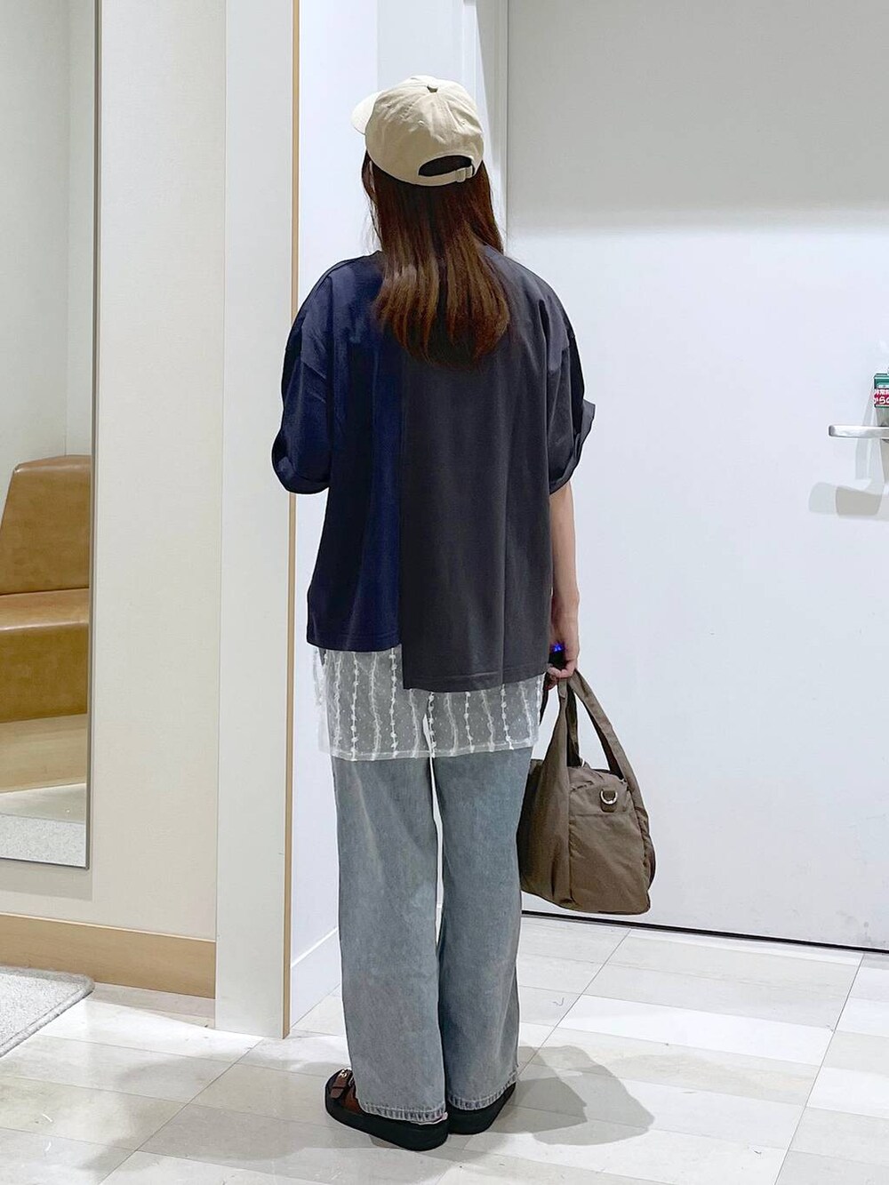 ブルー系のデニムパンツ、ブラウン系のサンダル、ベージュ系のその他小物を着用したレディースの夏コーディネートの3枚目の写真