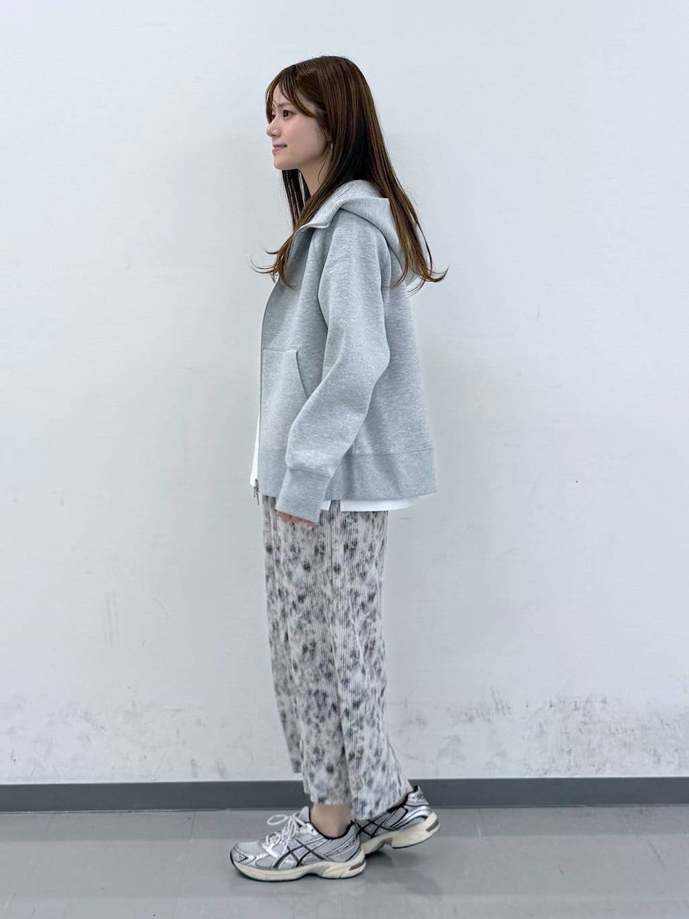 グレー系のパーカー、ホワイト系のTシャツ/カットソー、ベージュ系のスカートを着用したレディースの春コーディネートの2枚目の写真