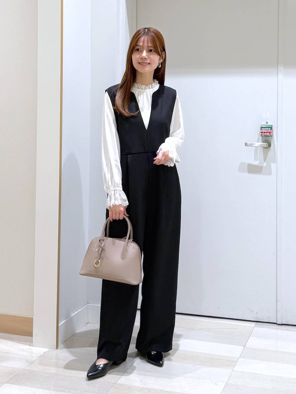 ベージュ系のショルダーバッグ、ブラック系のパンプス、ホワイト系のシャツ/ブラウスを着用したレディースの冬コーディネートの4枚目の写真