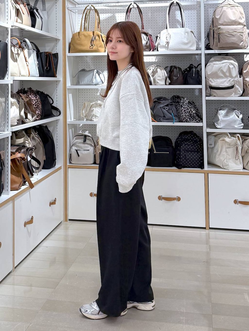 ブラック系のその他パンツ、イエロー系のショルダーバッグ、シルバー系のネックレスを着用したレディースの冬コーディネートの2枚目の写真