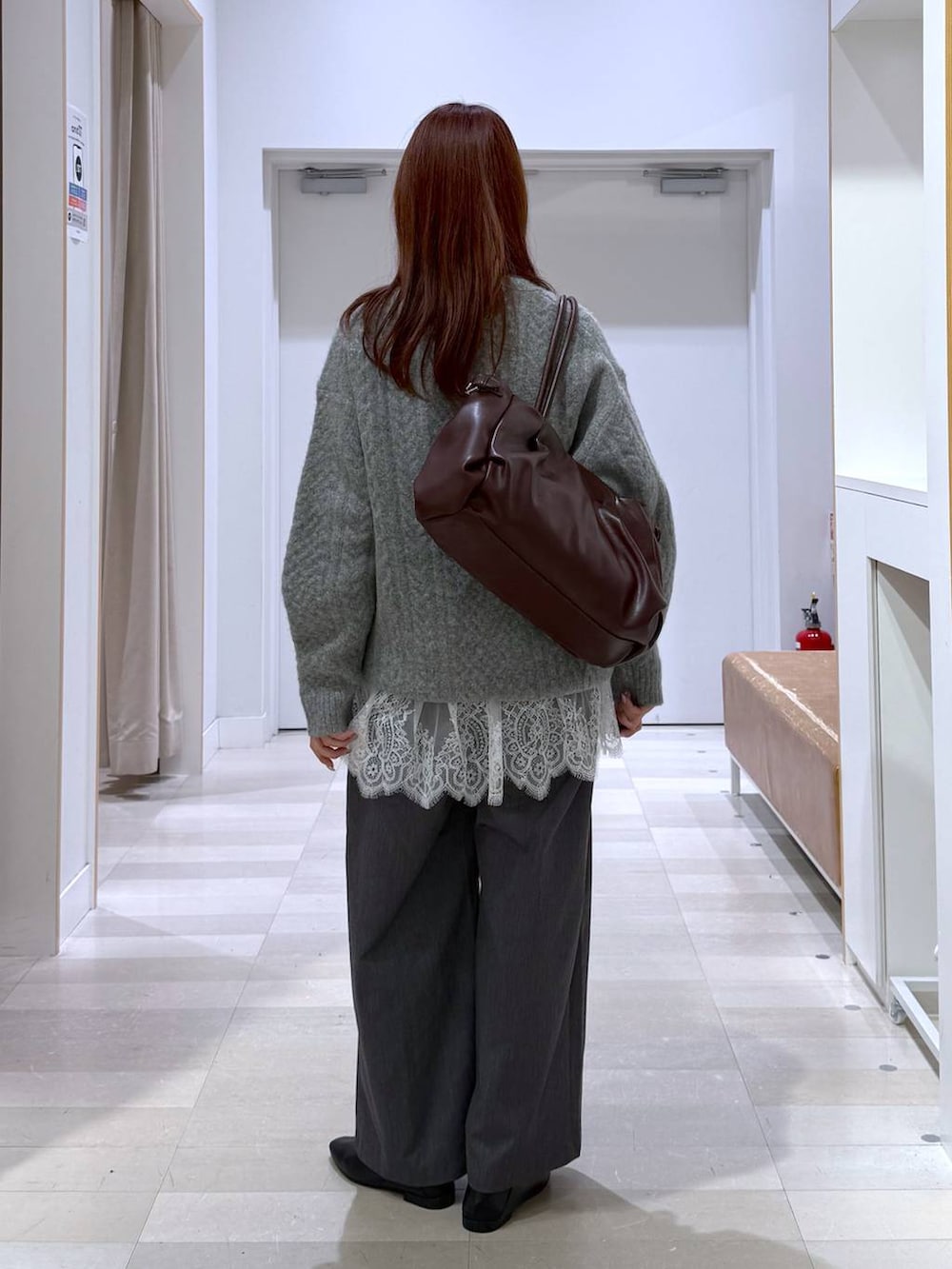 ブラック系のパンプス、レッド系のボストンバッグ、グレー系のその他パンツを着用したレディースの秋コーディネートの3枚目の写真