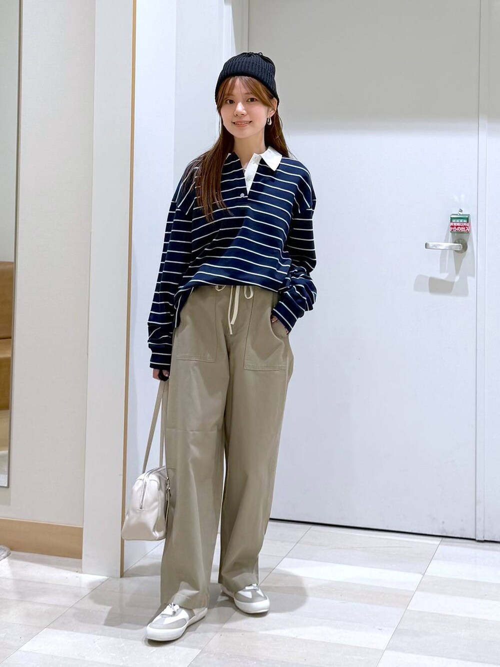 ホワイト系のスニーカー、ブルー系のスウェット、ベージュ系のショルダーバッグを着用したレディースの春コーディネートの4枚目の写真