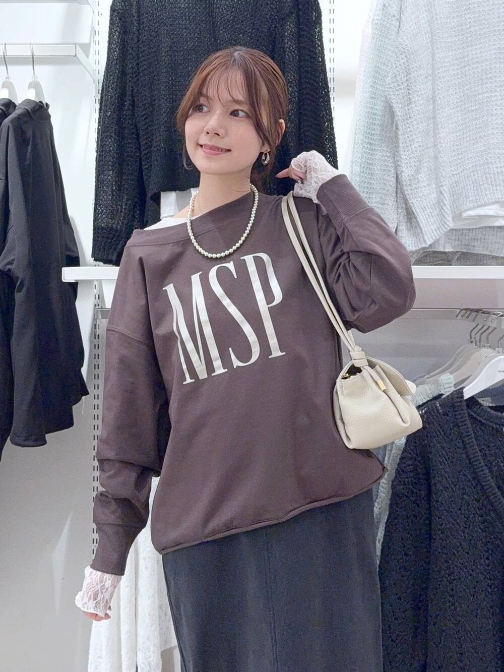 グレー系のスカート、ベージュ系のショルダーバッグ、ホワイト系のTシャツ/カットソーを着用したレディースの秋コーディネートの3枚目の写真