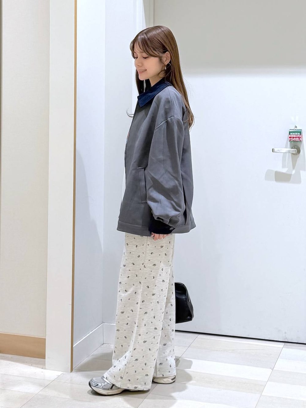 ホワイト系のTシャツ/カットソー、ブラック系のショルダーバッグ、グレー系のブルゾンを着用したレディースの春コーディネートの2枚目の写真