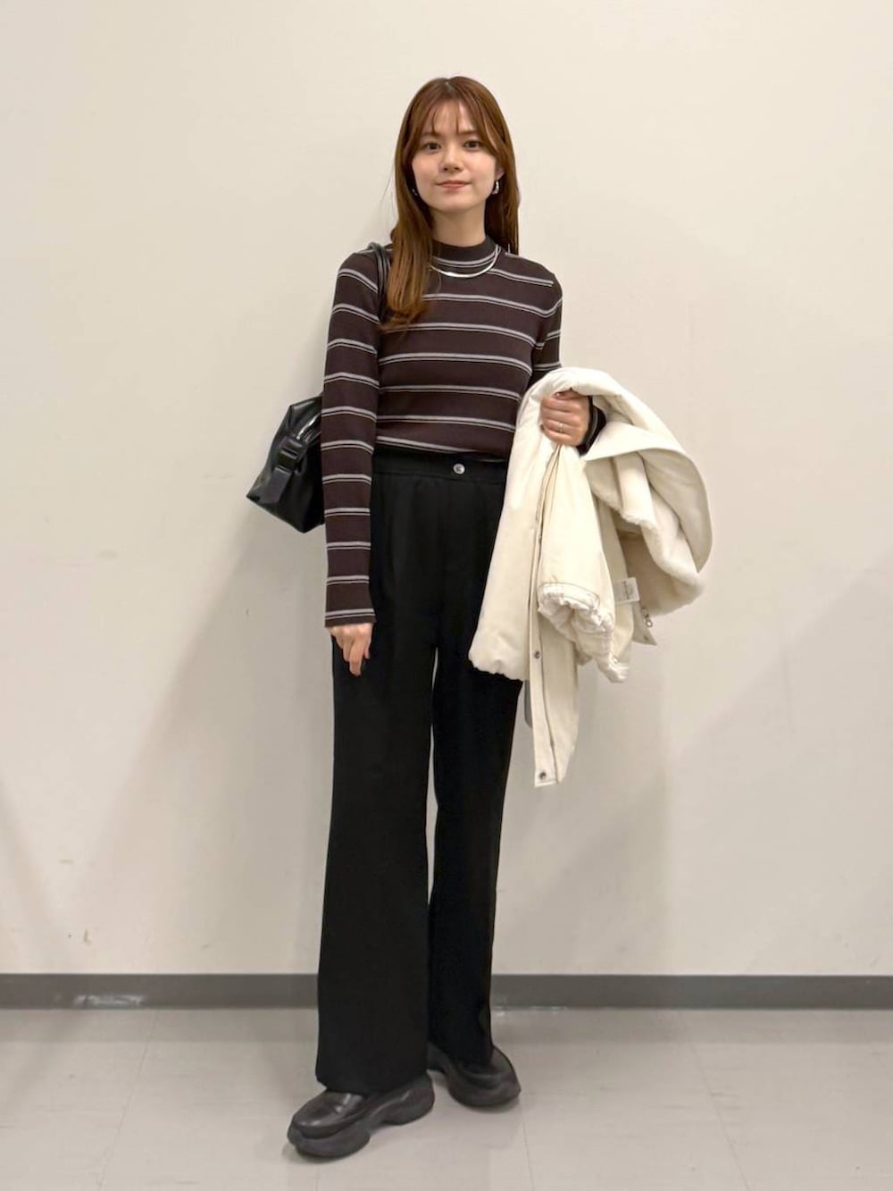 ブラック系のボストンバッグ、ブラック系のその他パンツ、ブラック系のブーツを着用したレディースの冬コーディネートの4枚目の写真