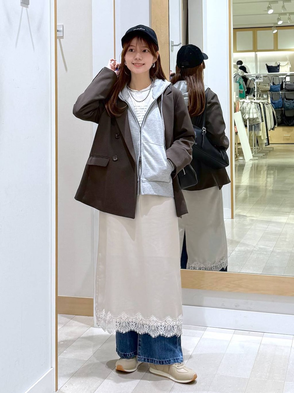 ブルー系のデニムパンツ、ベージュ系のスニーカー、ブラウン系のテーラードジャケットを着用したレディースの冬コーディネートの6枚目の写真