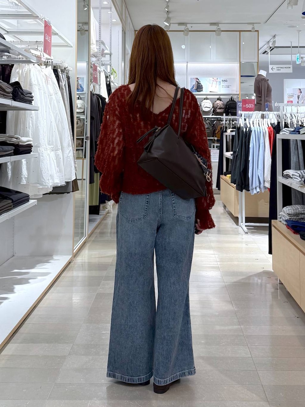 ブラウン系のパンプス、レッド系のカーディガン/ボレロ、ブラウン系のボストンバッグを着用したレディースの秋コーディネートの3枚目の写真