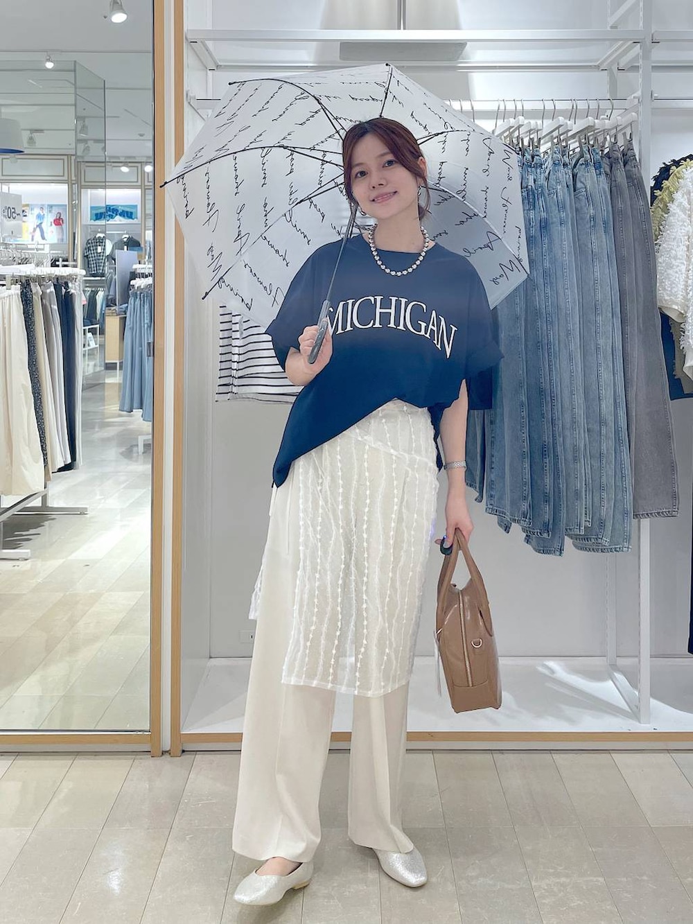 ベージュ系のパンプス、ベージュ系のボストンバッグ、ブルー系のTシャツ/カットソーを着用したレディースの夏コーディネートの4枚目の写真