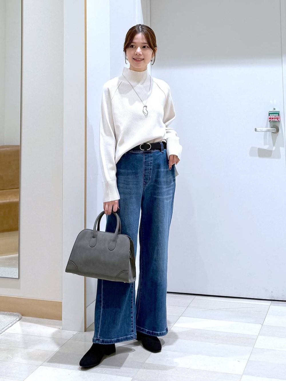 ブラウン系のチェスターコート、グリーン系のショルダーバッグ、ホワイト系のニット/セーターを着用したレディースの秋コーディネートの5枚目の写真