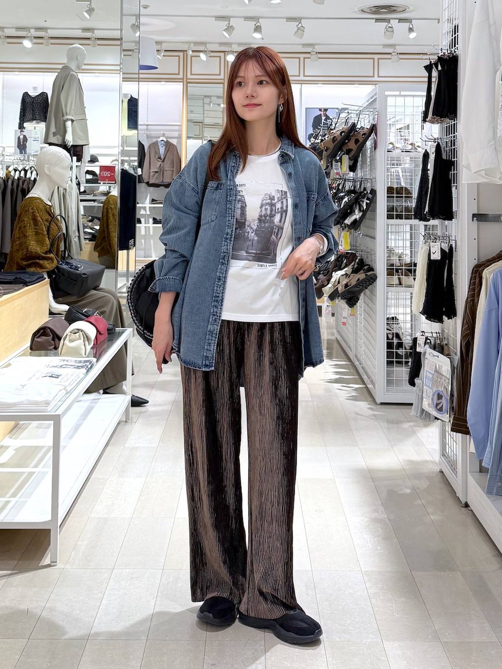 ブラック系のその他シューズ、ホワイト系のTシャツ/カットソー、ブラック系のショルダーバッグを着用したレディースの秋コーディネートの4枚目の写真